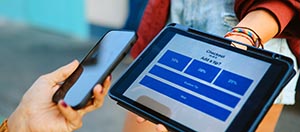 Person using a phone to pay on a tablet