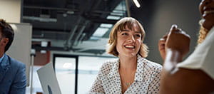People smiling in office with laptop