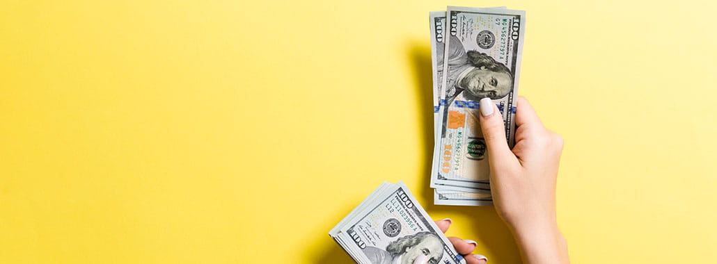 Person counting $100 bills