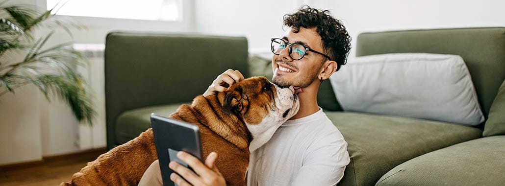 Dog licking a person looking at a device