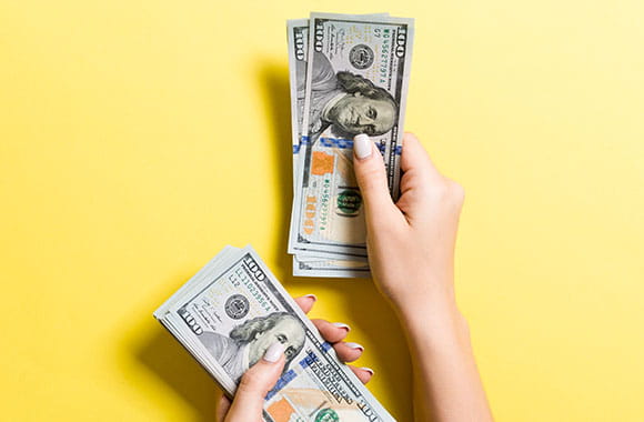 Person counting $100 bills