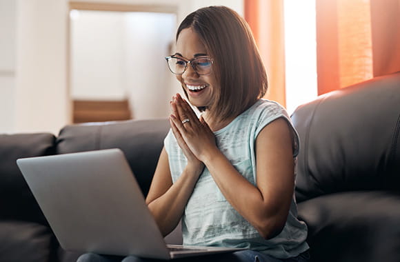 Person excited and looking at a laptop