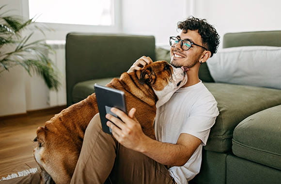 Dog licking a person looking at a device