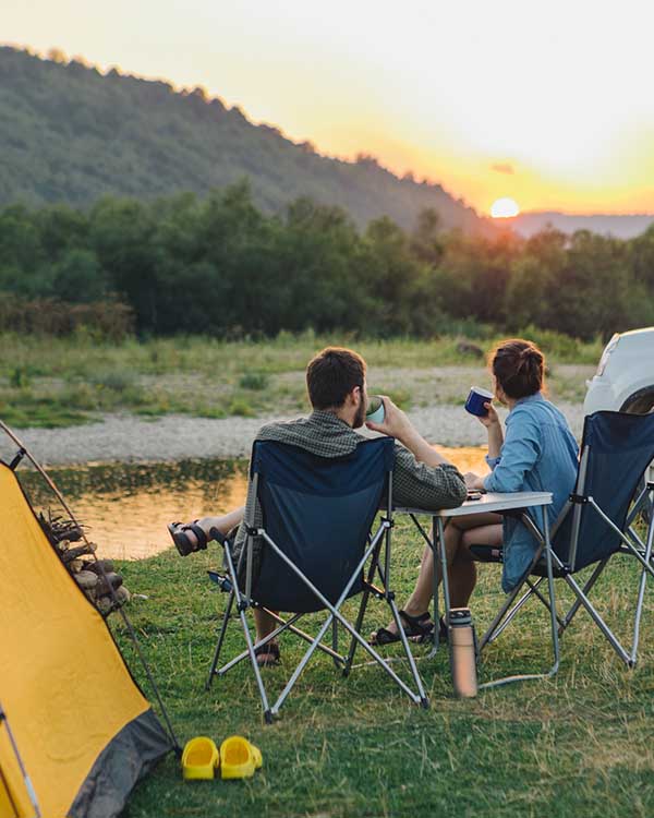 Two people looking at sunset near scenic campground