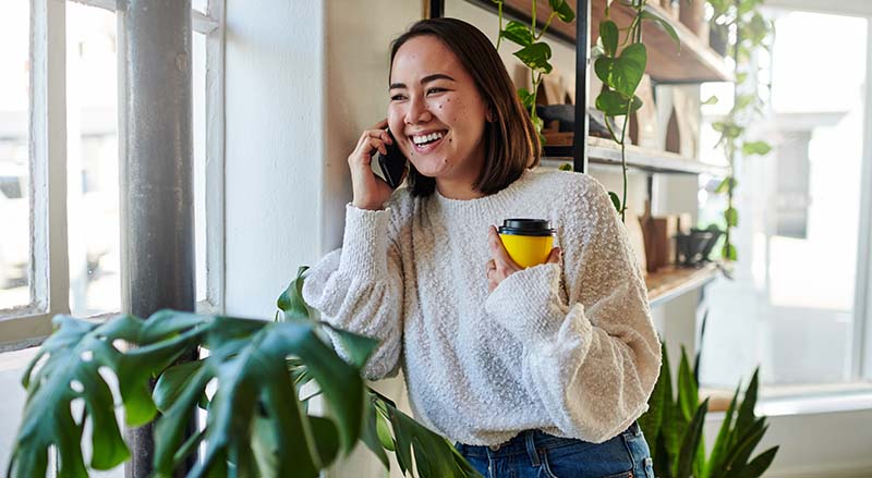 Person talking on phone holding coffee cup