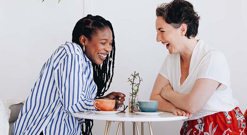 Two people laughing at a small table