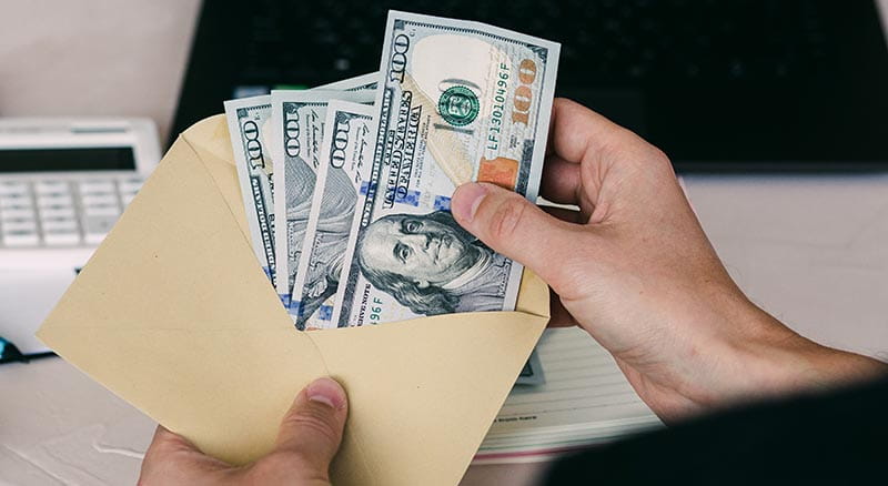 Person with an envelope of $100 bills
