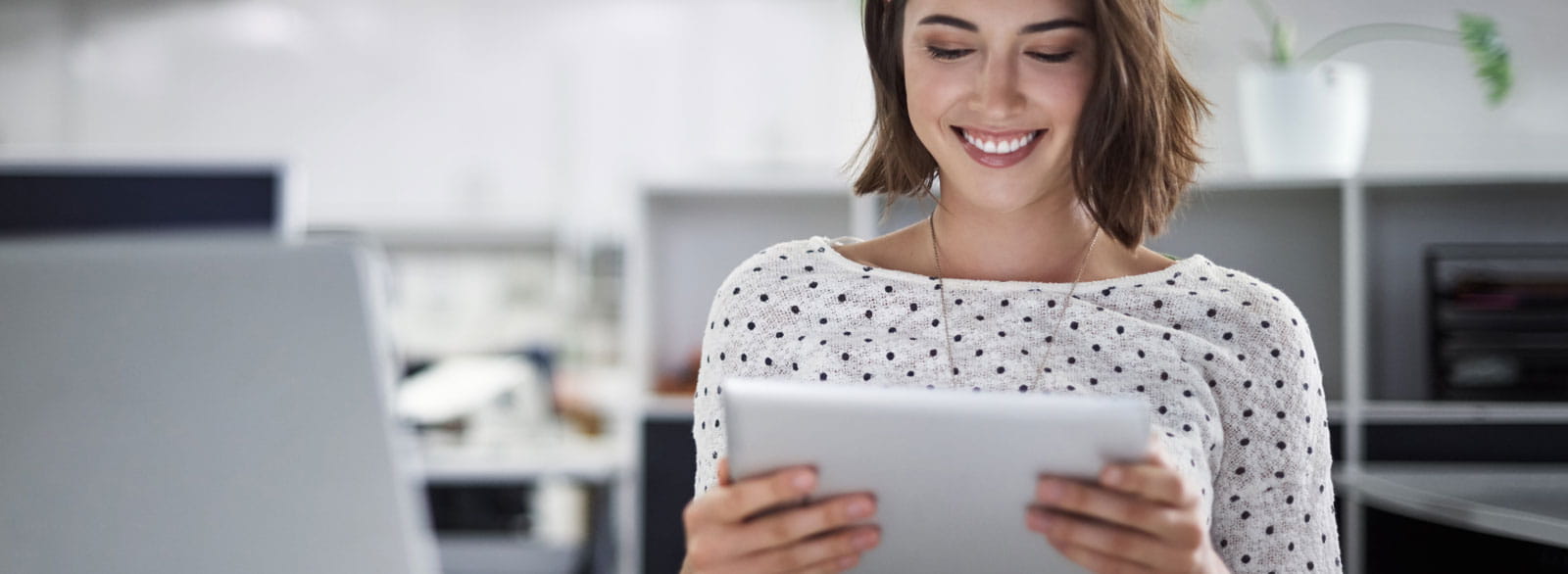 Smiling woman uses Banner Bank's Online Banking and Bill Pay from her tablet.