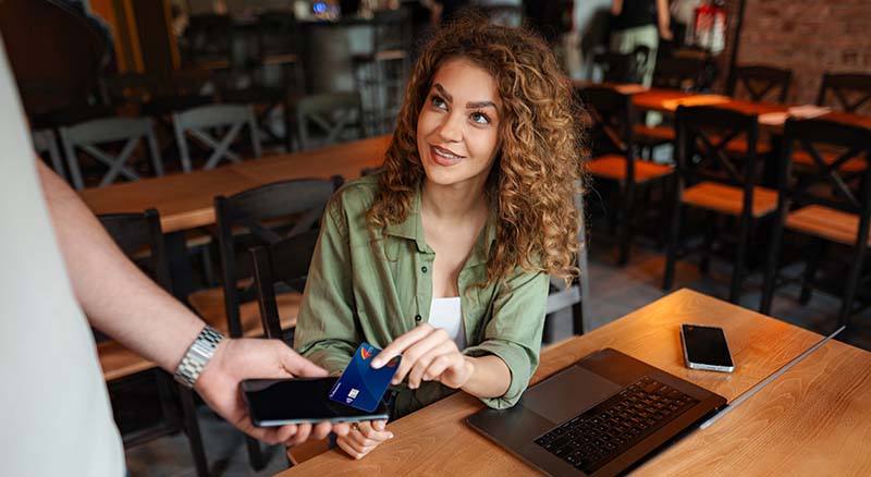 Person using a TruRewards card to pay with a mobile reader