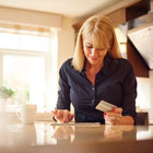 Smiling woman looks at credit card statement