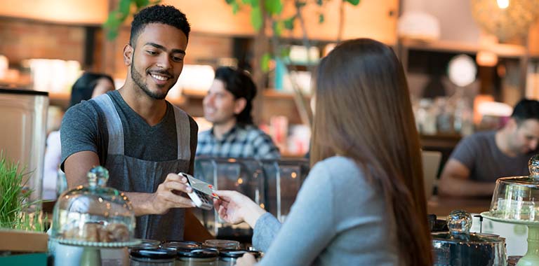 Person paying with credit card at bakery