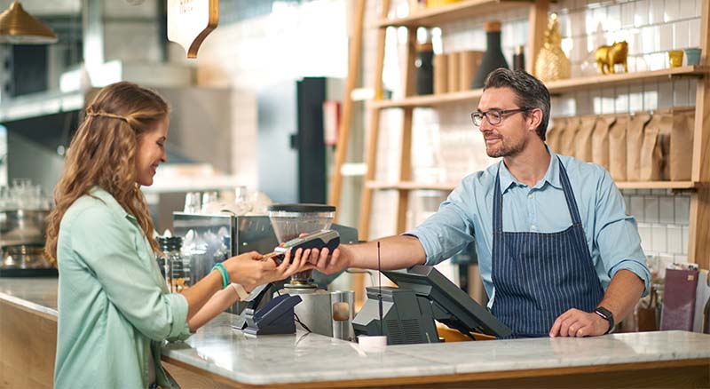 Woman paying merchant with debit card