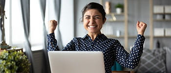 woman looks at laptop in excitement