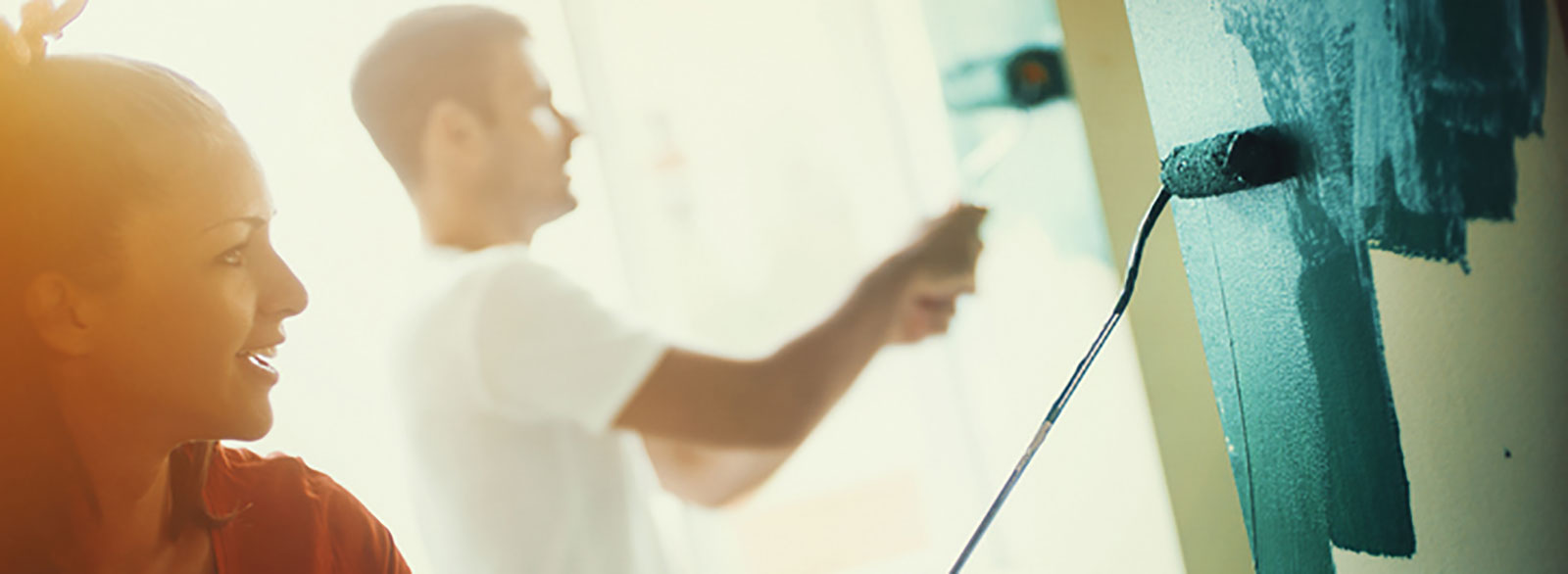 Man and woman paint an interior wall
