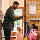 Teacher high fiving kids entering classroom
