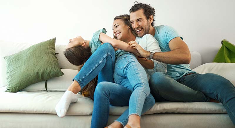 Family laughing on couch