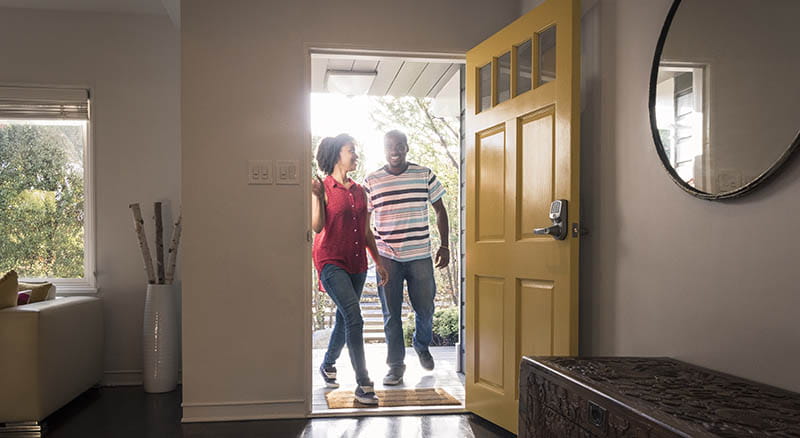 Couple walking through the front door to a home