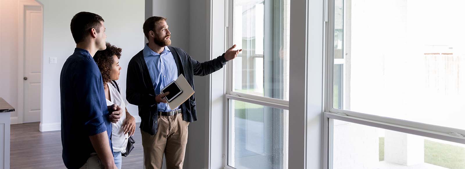 Couple looking inside a new home with a realtor