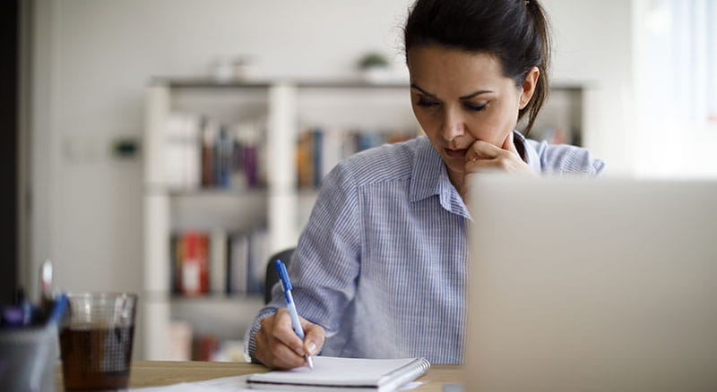 Person at laptop taking notes