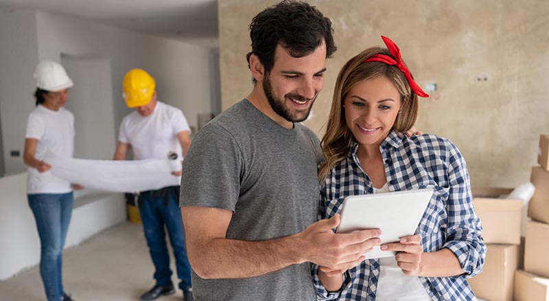 Contractor working on a house while couple selects finishes