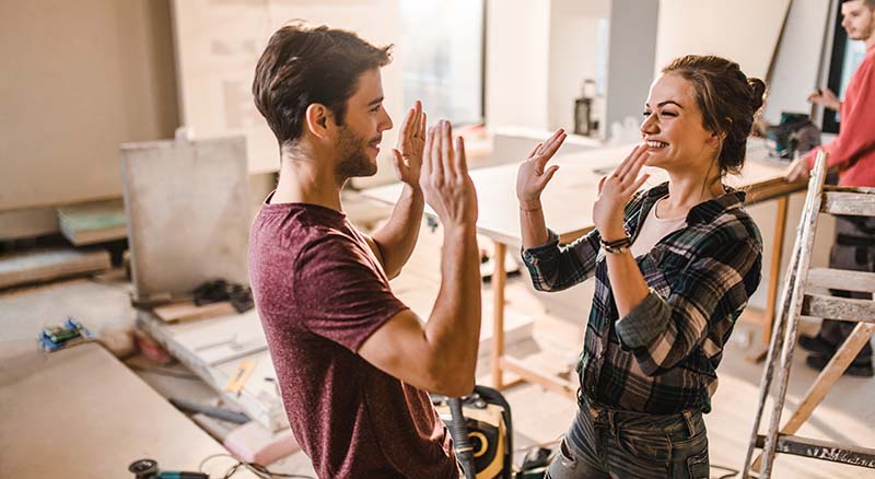 Couple high fiving in home renovation space