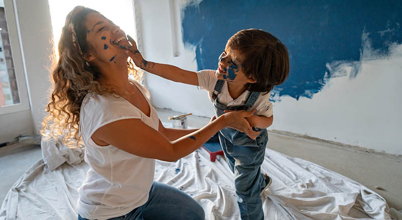 Child and parent playing with wall paint