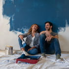 Couple takes a break from painting wall