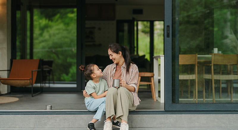 Two people hugging outside of a home