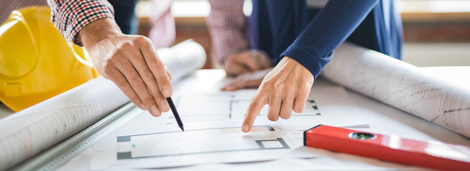 Close-up of two people's hands pointing to renovation plans