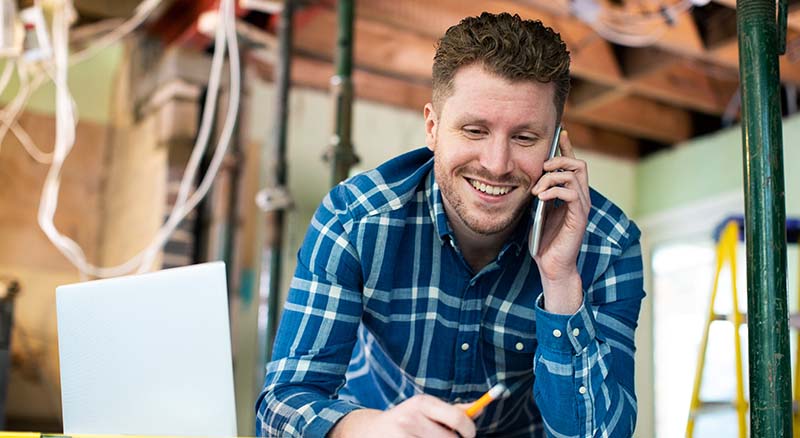 person using loan by phone at construction site