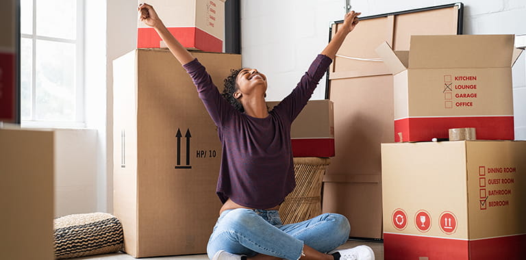 Woman sitting on the floor with arms outstretched.