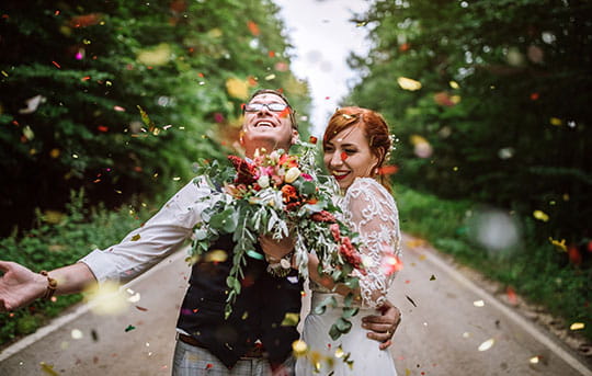 Bride and groom being showered with confetti