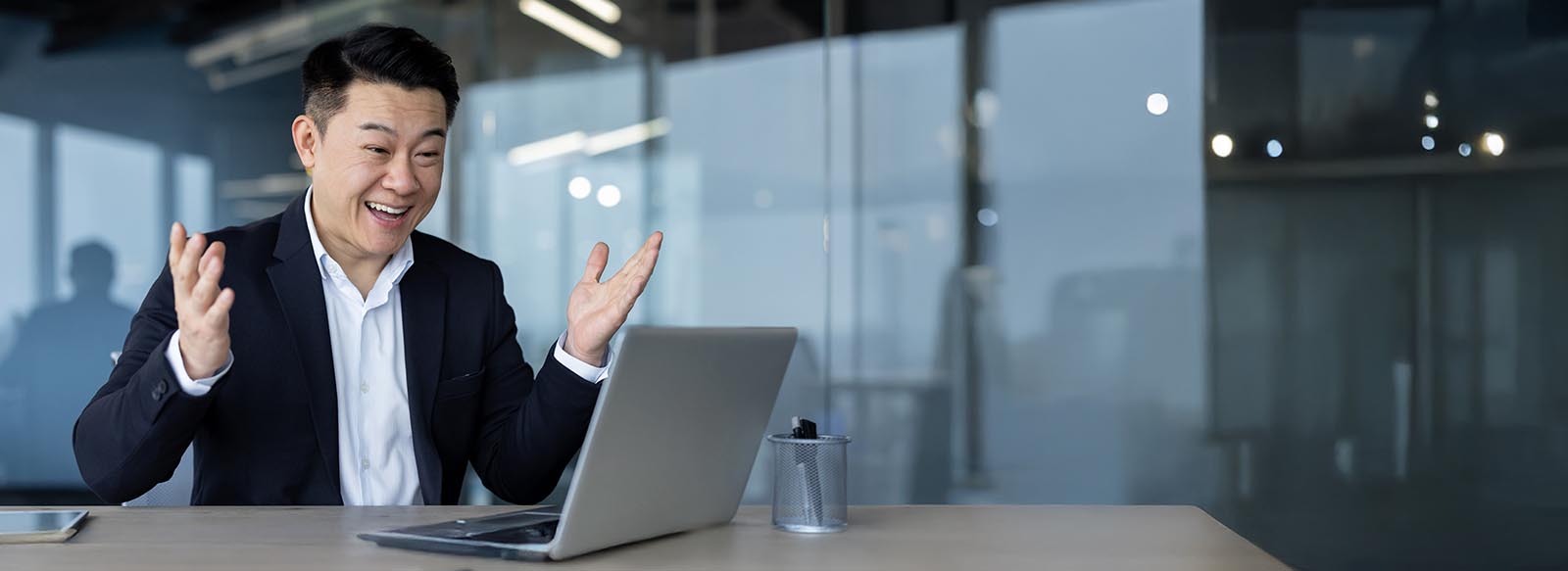 Excited person looking at a laptop in an office