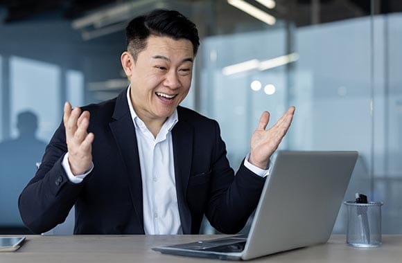Excited person looking at a laptop