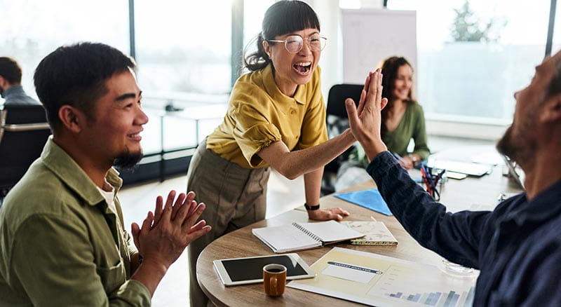 colleagues high fiving and another clapping