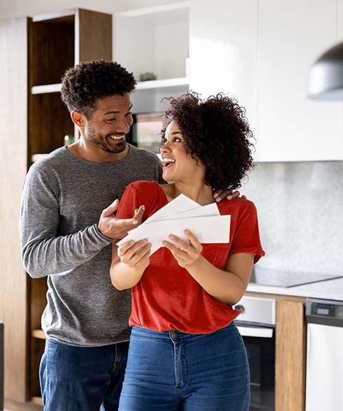 Couple smiling and looking at mail in kitchen