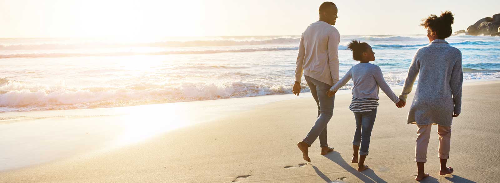 Family walks along beach
