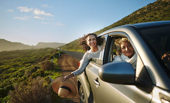 Two people looking out car windows on the road