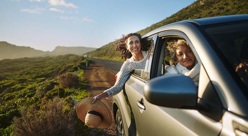 Two people looking out car windows on the road