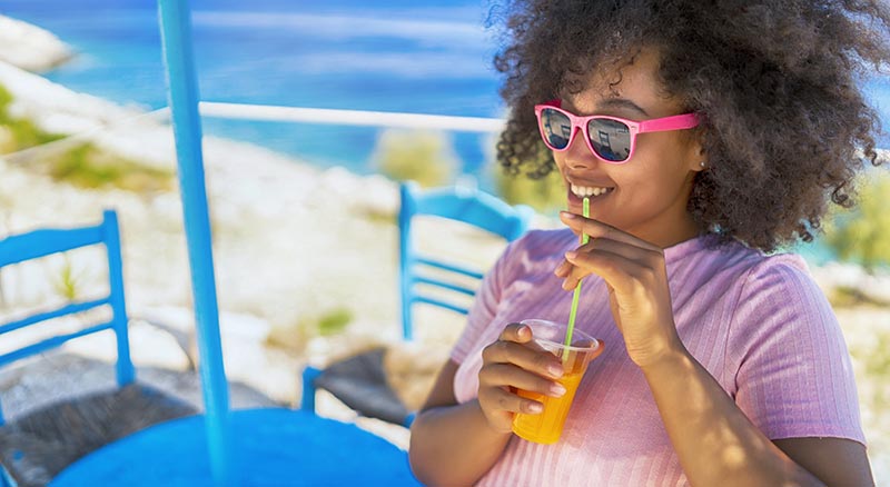 Person drinking juice near beach