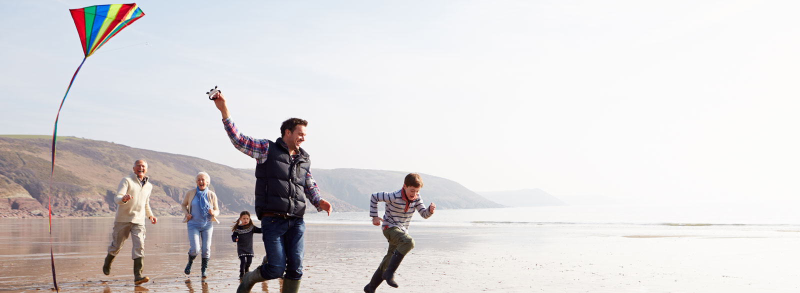 Family flies kite on the beach