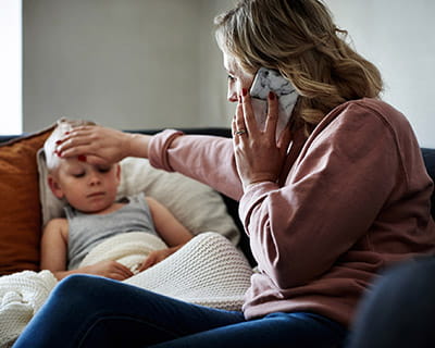 Person on the phone while checking childs temperature