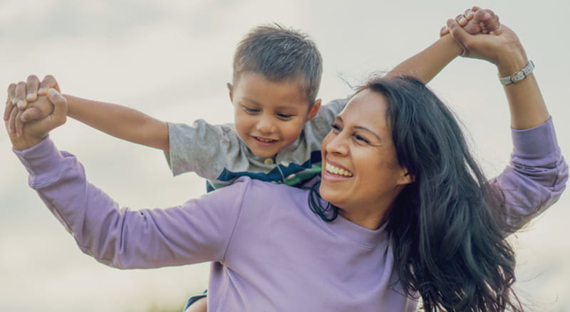 Mother and son holding hands with arms out