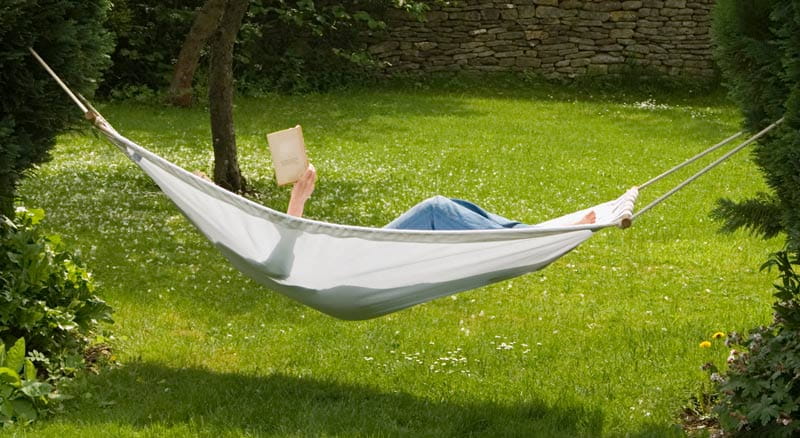 Person reading a book in a hammock on a sunny day