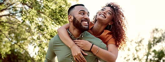 Couple laughing and hugging outside