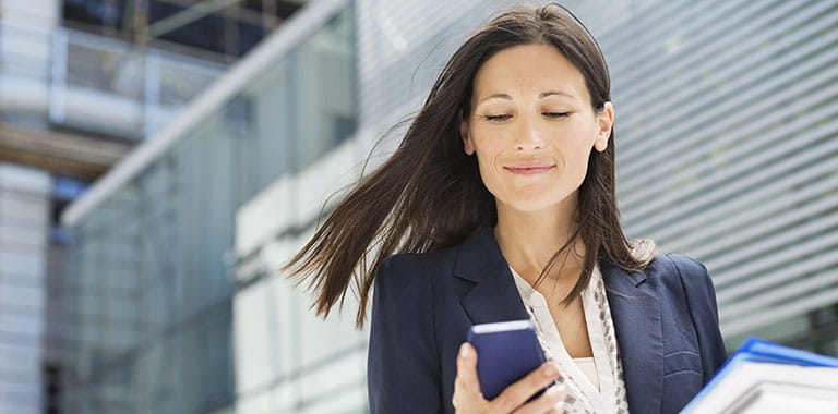 Person outside office building with phone in hand