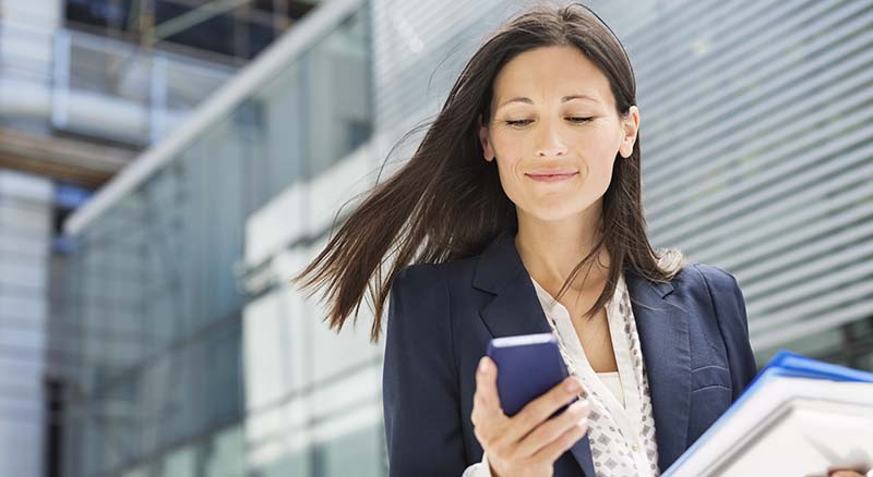 Person using phone outside high rise building