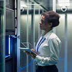 women in an office with a laptop looking at a power wall