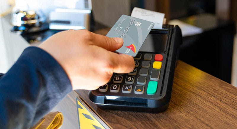 Hand placing card over a card machine