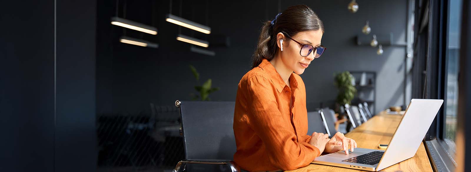 Person looking at laptop in workspace